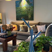 "Blue decorative sticks in a cozy, neutral-toned living room with greenery and colorful patterned pillows."