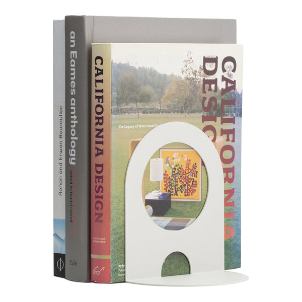 White bookend featuring a cut-out design, paired with colorful book spines in shades of green, blue, and yellow.