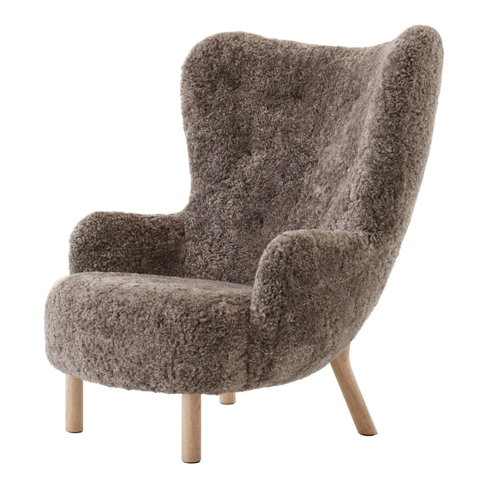 Fuzzy gray armchair with curved back and wooden legs, perfect for adding cozy texture to any space.