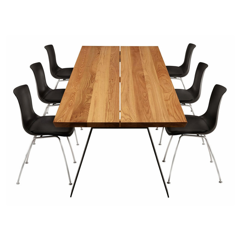 Wooden table with a natural finish paired with sleek black chairs featuring a minimalist design.