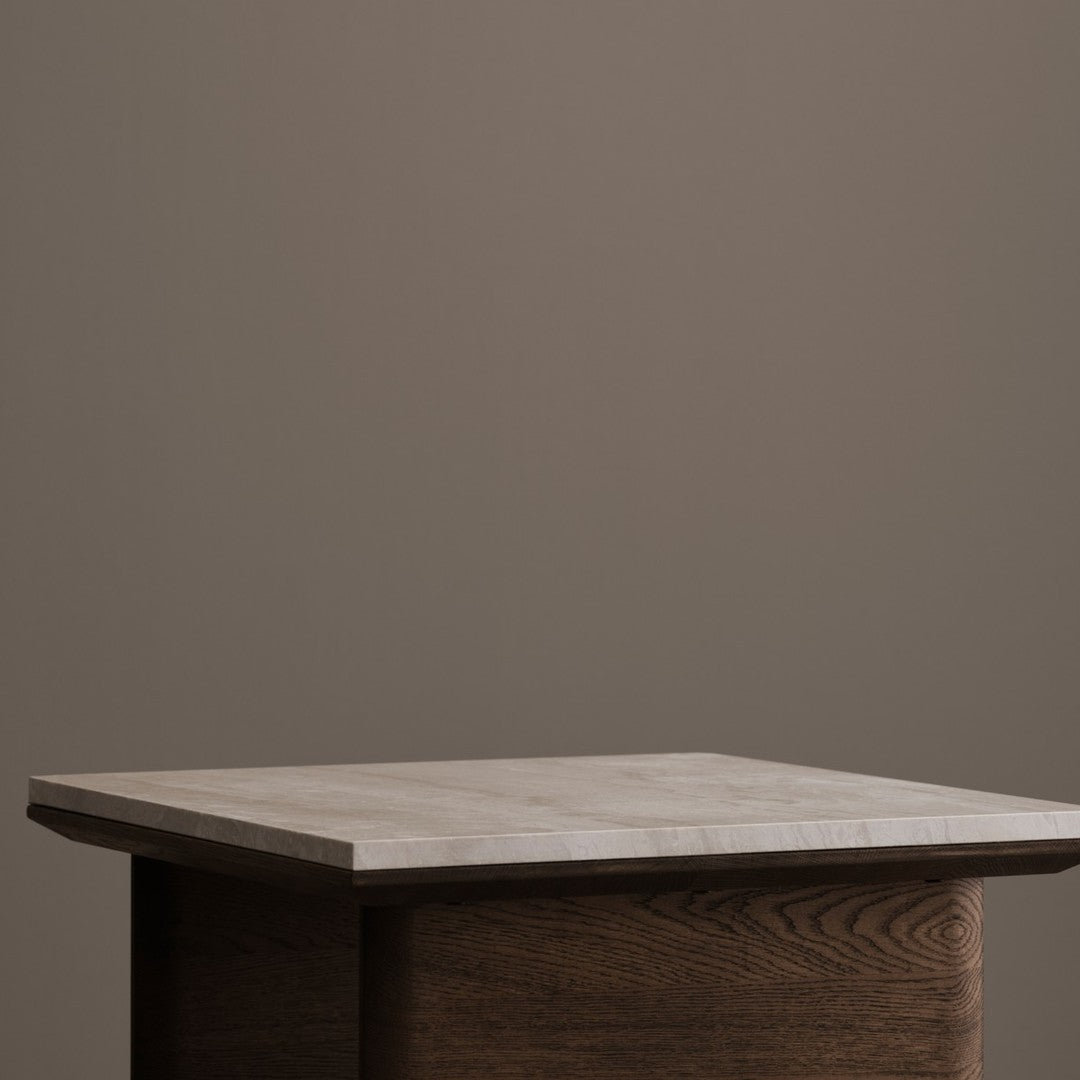 Wooden table with a light marble top, set against a neutral taupe background, showcasing modern design aesthetics.