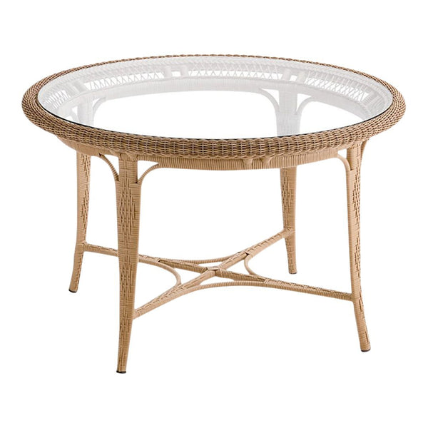 Round wicker table in natural tones with a glass top, featuring intricate woven patterns and a smooth finish.
