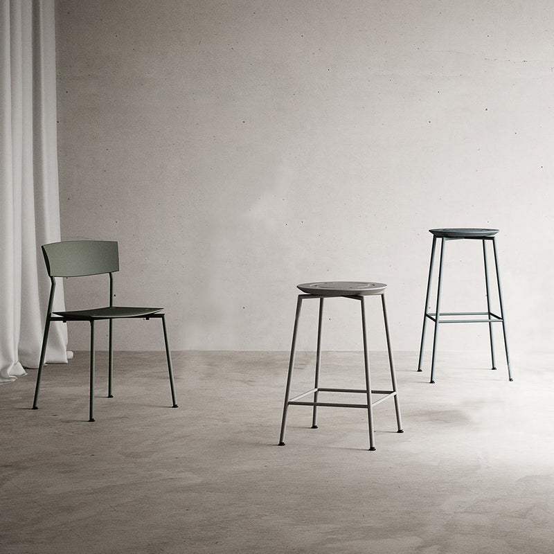 Set of three modern metal stools in muted green and grey tones, featuring minimalist design and sleek lines.