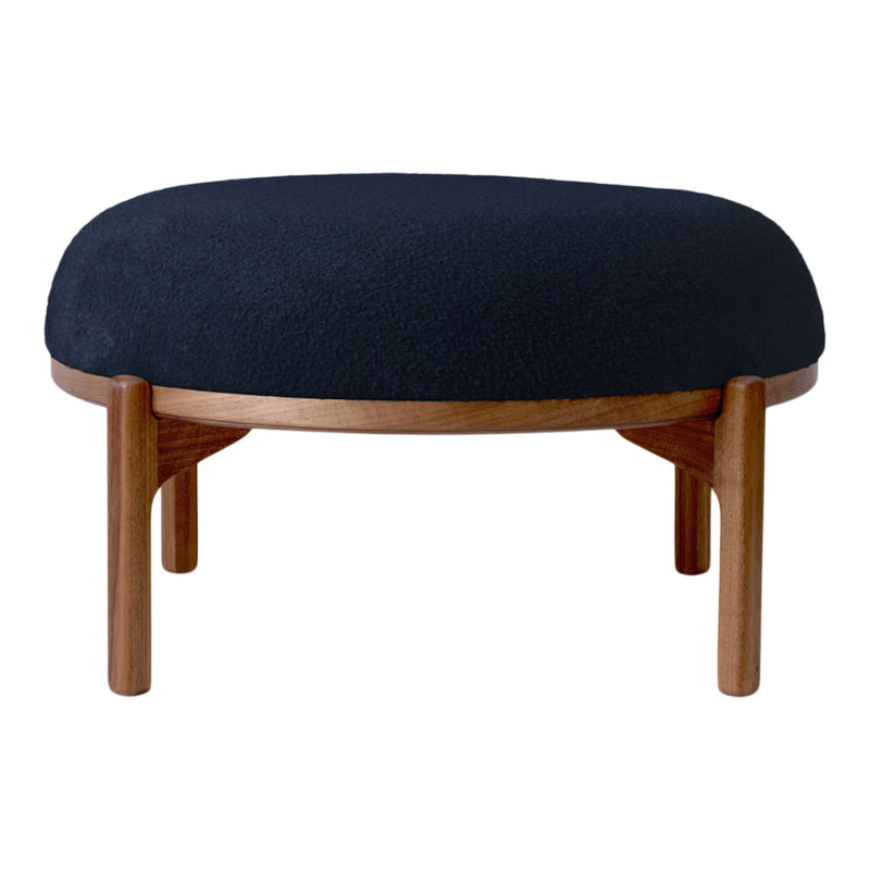 Black upholstered ottoman with a smooth, rounded shape and wooden legs, perfect for modern interiors.