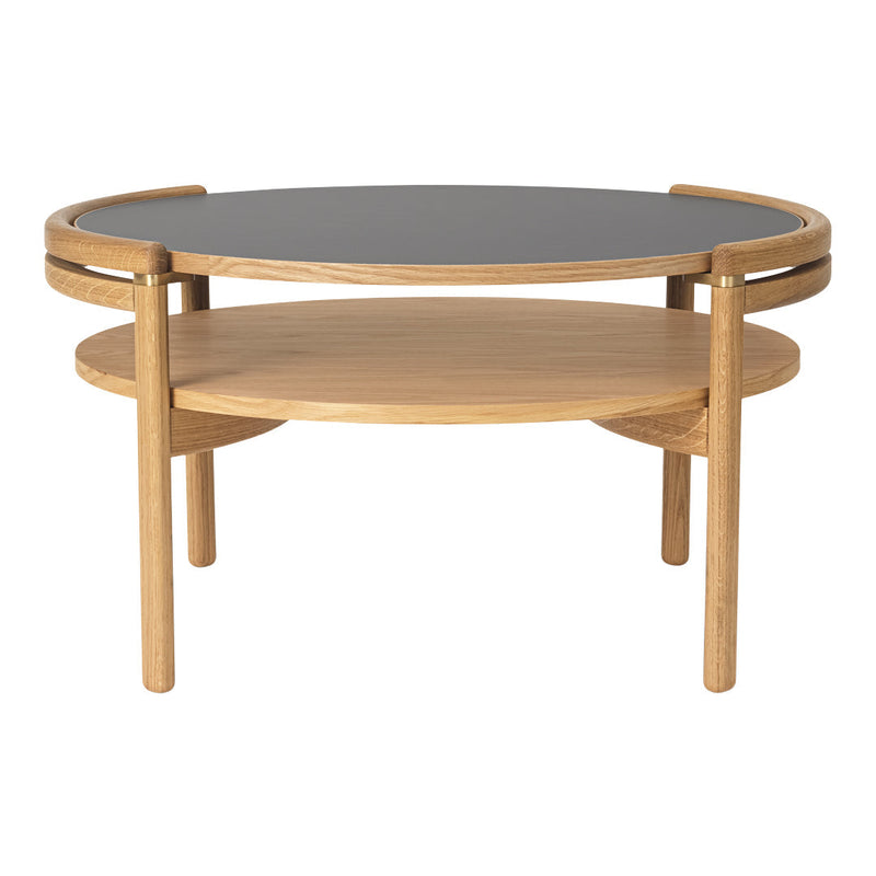 Elegant round coffee table with a black top and natural oak wood base, showcasing a minimalist design.