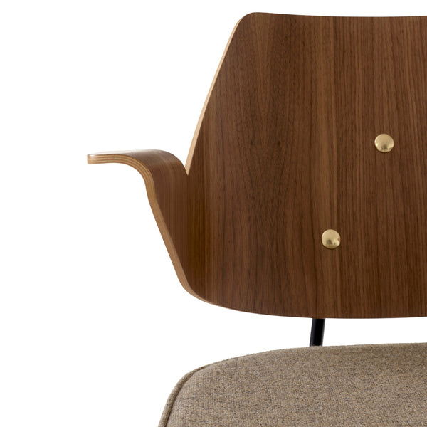 Wooden chair back with warm brown tones and brass accents; cozy gray fabric seat. Modern design with smooth curves.
