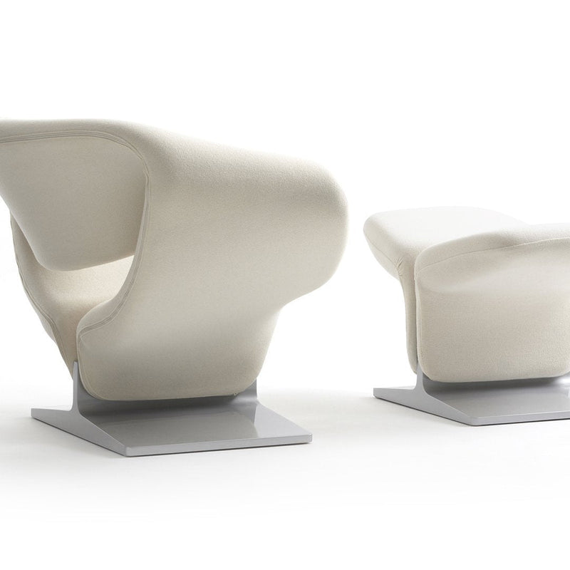 Elegant white lounge chair and ottoman with smooth curves, featuring a minimalist silver base for a modern touch.
