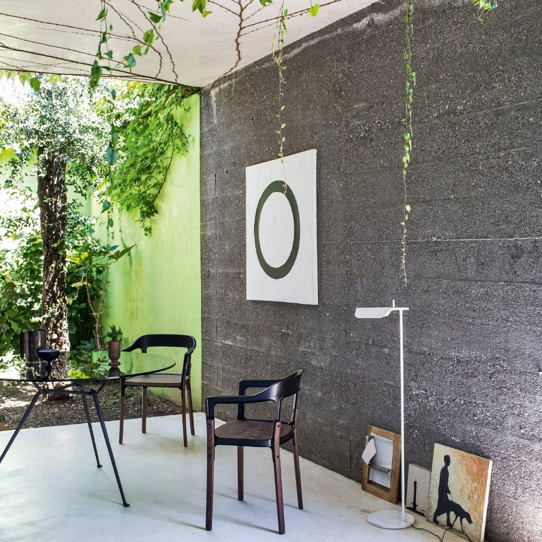 Chic interior featuring green walls, dark gray textures, and minimalist black chairs with wooden accents, creating a modern vibe.