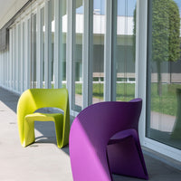 Vibrant lime green and deep purple modern chairs with sleek, ribbed patterns in a bright, contemporary setting.