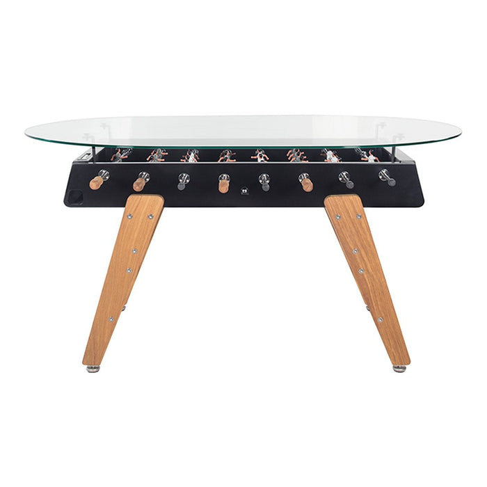 "Modern foosball table with sleek black body, natural wood legs, and a transparent glass top."