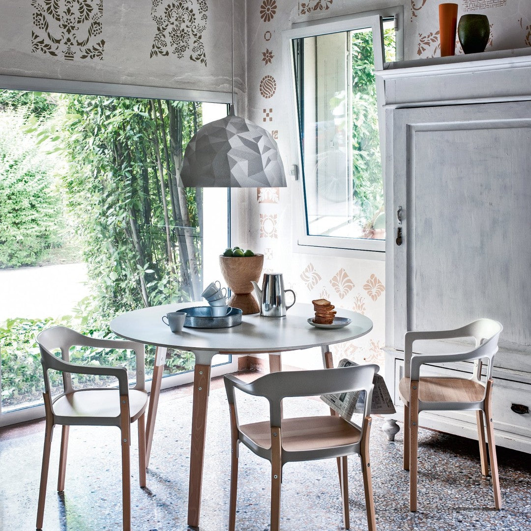 Modern dining room with white and gray tones, natural wood accents, and intricate patterned wallpaper in earthy hues.