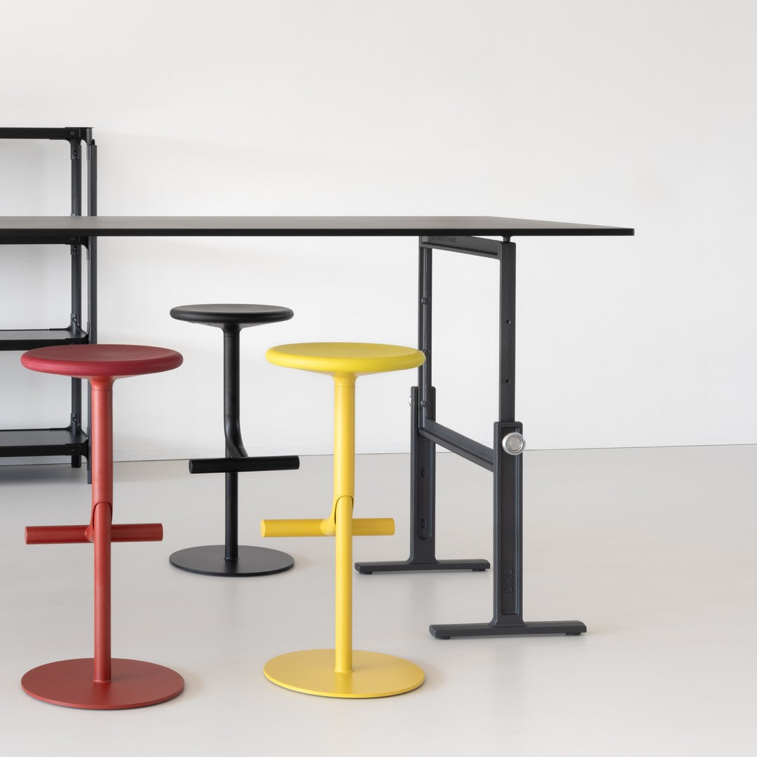 Colorful bar stools in red, yellow, black, and gray with sleek, modern designs on a minimalist background.