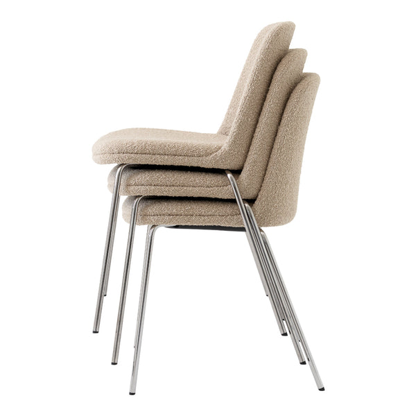 Stacked beige chairs with textured upholstery and sleek chrome legs, perfect for modern interiors.