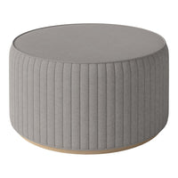 Round gray upholstered ottoman with vertical ribbed texture and wooden base. Ideal for modern decor.