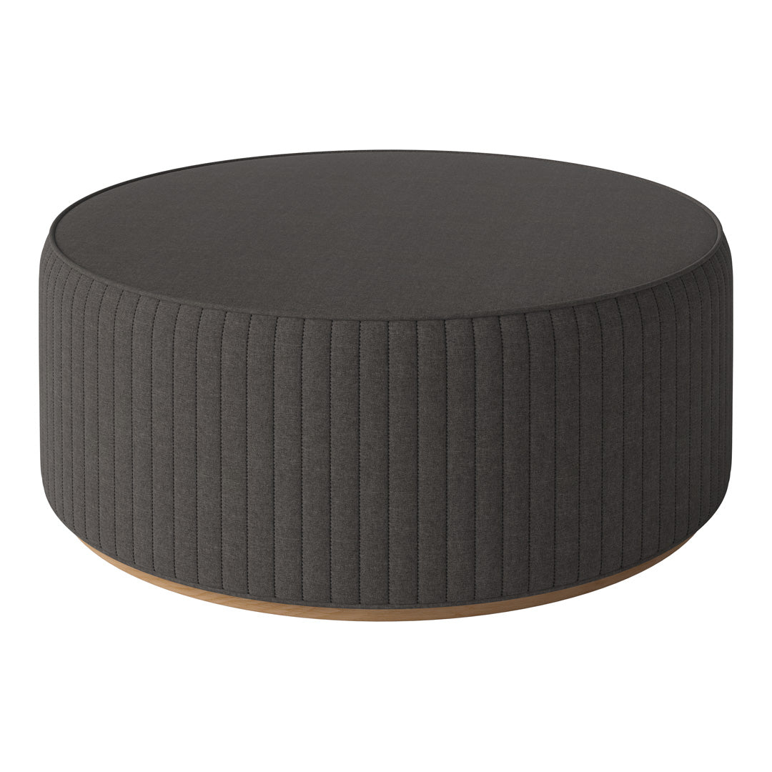 Round gray upholstered ottoman with vertical ribbed pattern and wooden base, perfect for modern decor.