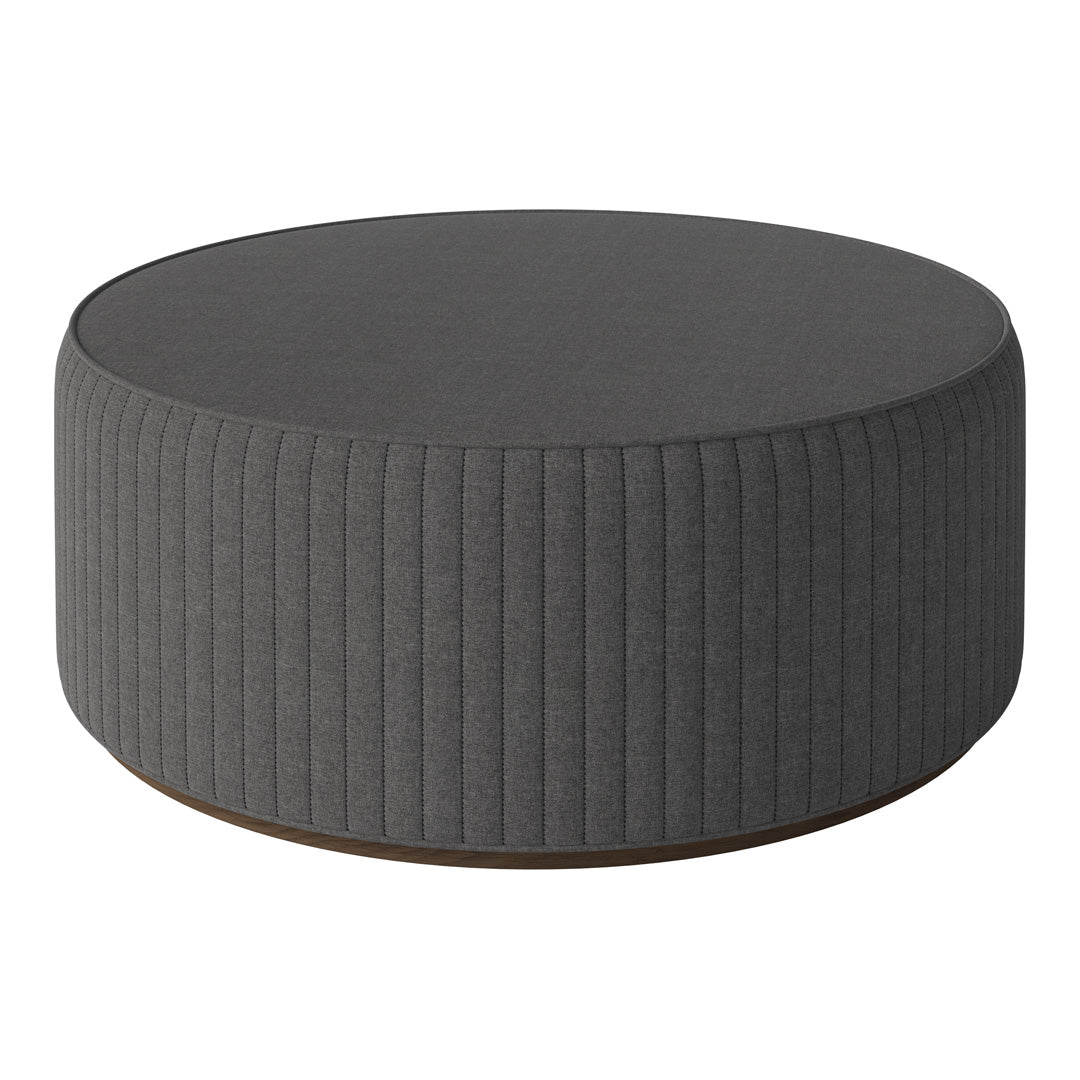 Round gray pouf with ribbed texture and smooth top, perfect for modern living spaces.