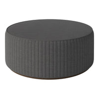 Round gray pouf with ribbed texture and smooth top, perfect for modern living spaces.
