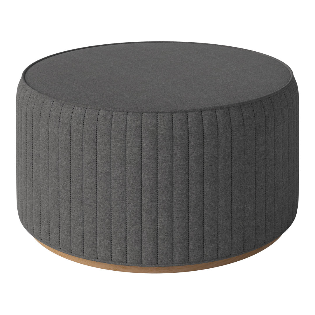 Round gray upholstered ottoman with vertical ribbed texture and wooden base. Stylish and modern furniture piece.