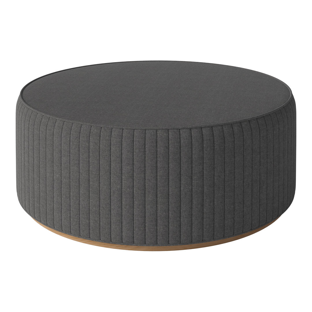 Gray ribbed round ottoman with a smooth wooden base, perfect for modern home decor.