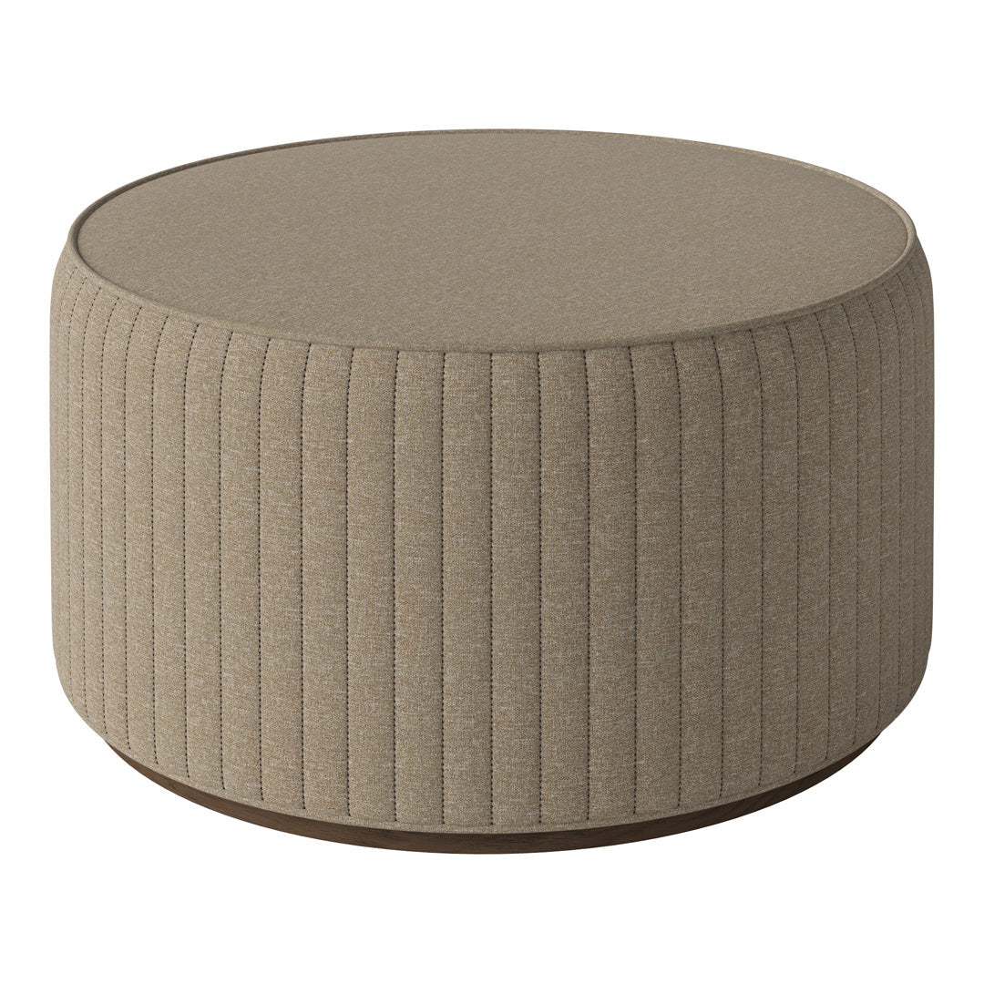 Round ottoman in textured beige fabric with vertical ribbed pattern and a sleek wooden base. Ideal for modern decor.