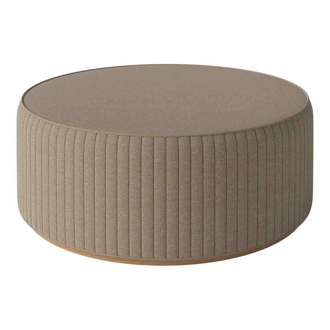 Round beige ottoman with textured ribbed pattern and smooth top, perfect for modern decor.