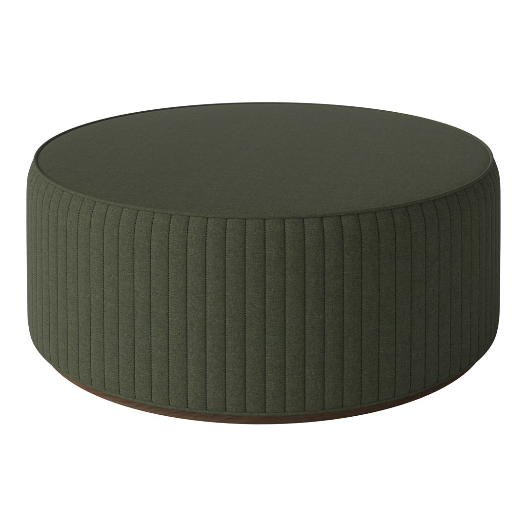 Round green ottoman with vertical ribbed pattern, perfect for modern decor.