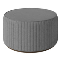 Gray round ottoman with vertical ribbed pattern and a smooth top, set on a brown wooden base. Ideal for modern decor.