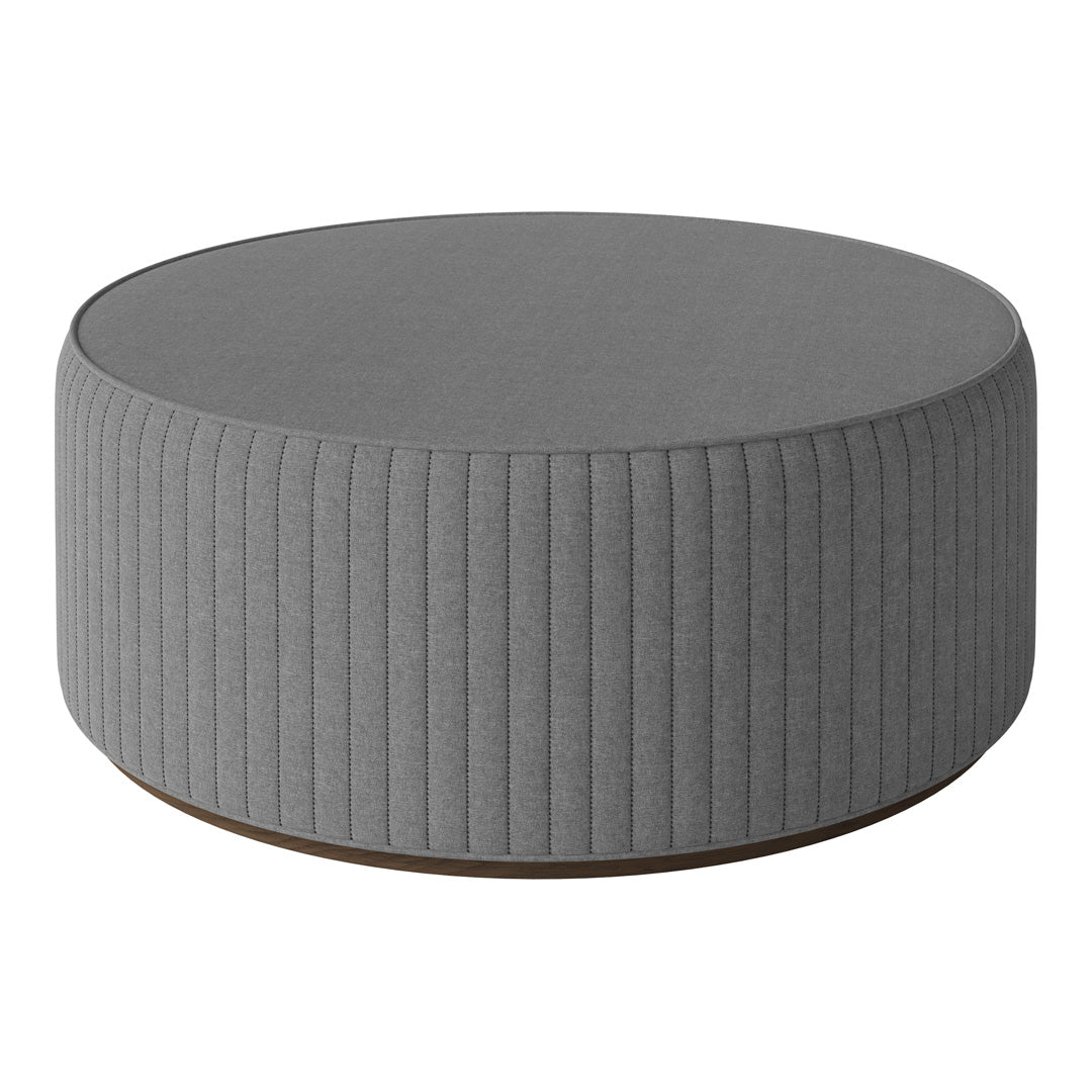 Gray round ottoman with ribbed texture and wooden base, perfect for modern decor.