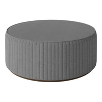 Gray round ottoman with ribbed texture and wooden base, perfect for modern decor.