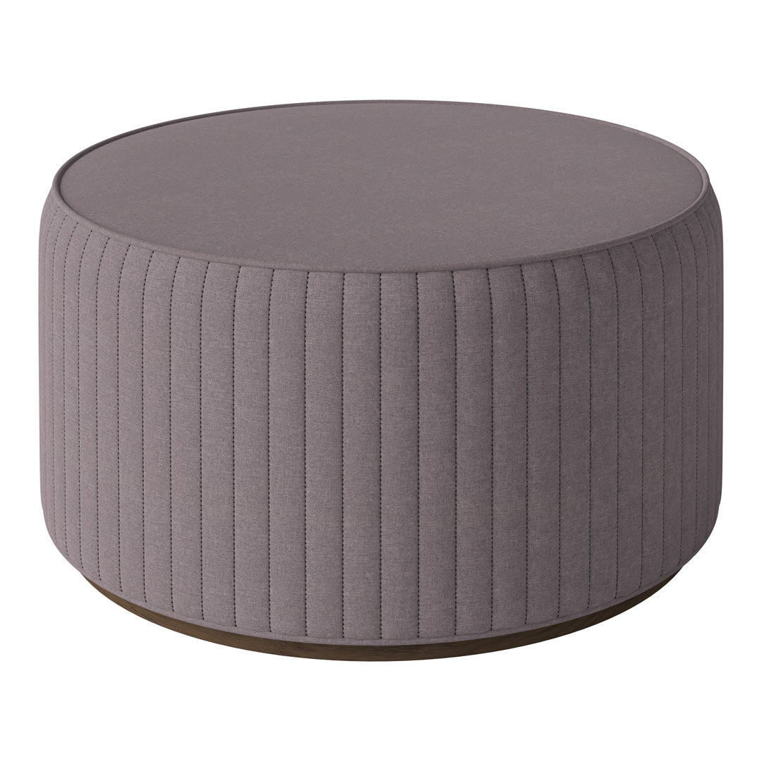 Round gray ottoman with vertical ribbed texture and a smooth top, perfect for modern decor.