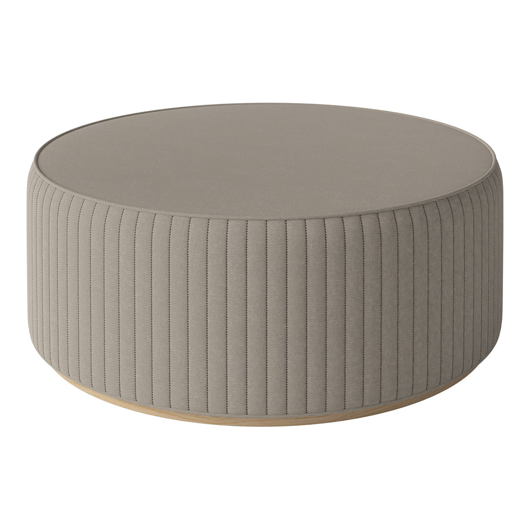 Round taupe ottoman with ribbed texture and a smooth top, perfect for modern decor.