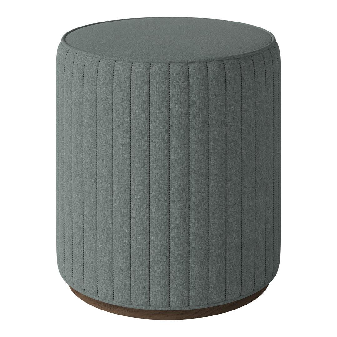 Gray ribbed fabric ottoman with a round shape and wooden base. Stylish and contemporary home decor piece.