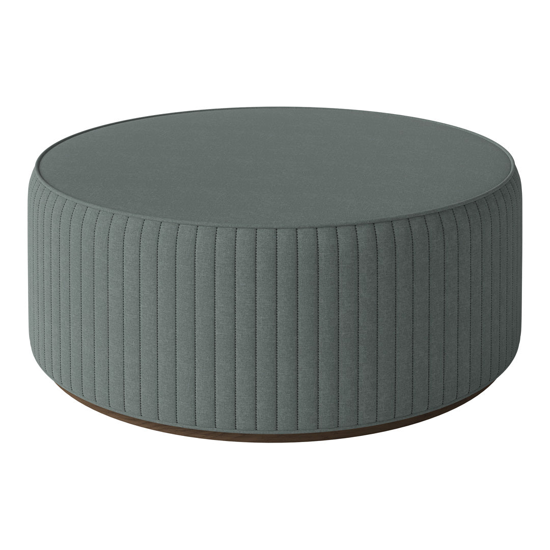Round ottoman in soft, muted teal with vertical ribbed texture and a wooden base for a modern touch.