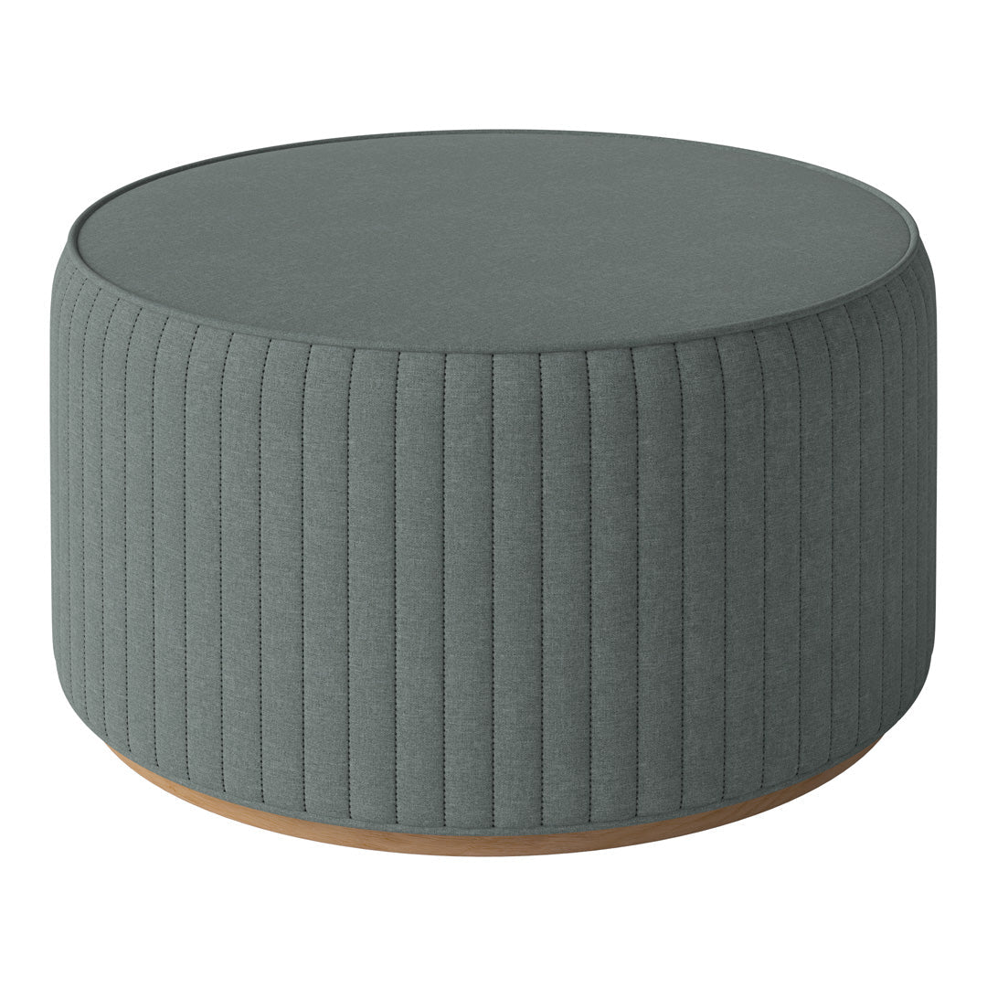 Round, ribbed ottoman in soft teal upholstery with a smooth, light wood base. Ideal for modern decor.