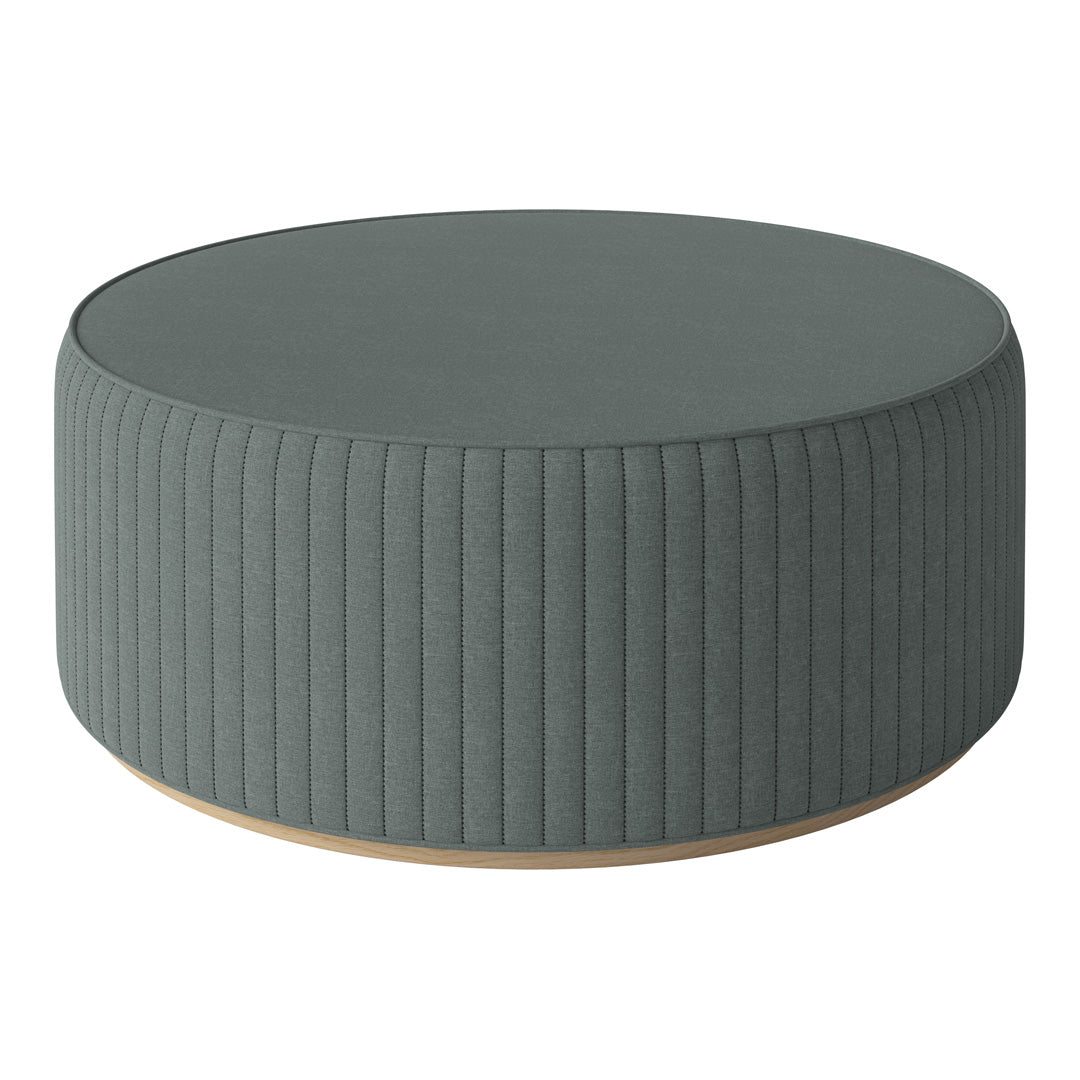 Round green ottoman with vertical ribbed texture and light wood base. Ideal for modern living spaces.