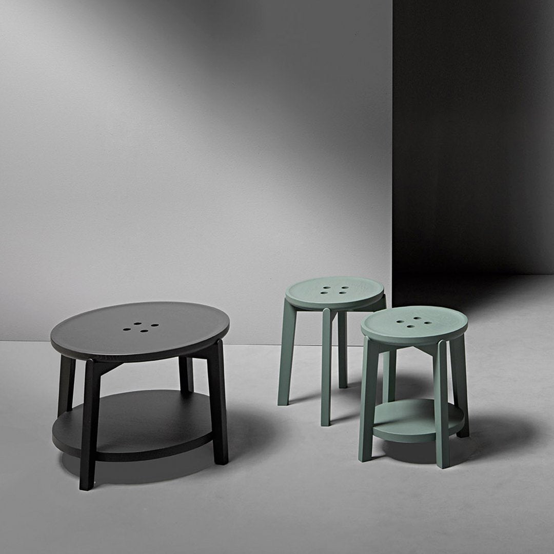 Stylish gray round coffee table and two mint green stools on a modern gray backdrop.