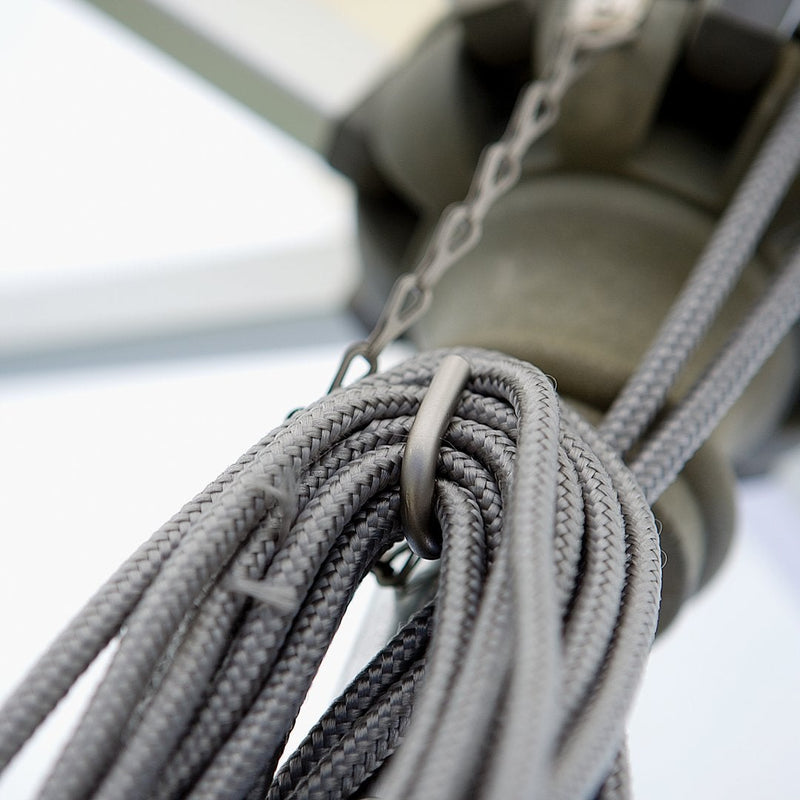 Gray braided rope coiled with a metallic clip and chain, against a blurred white background.