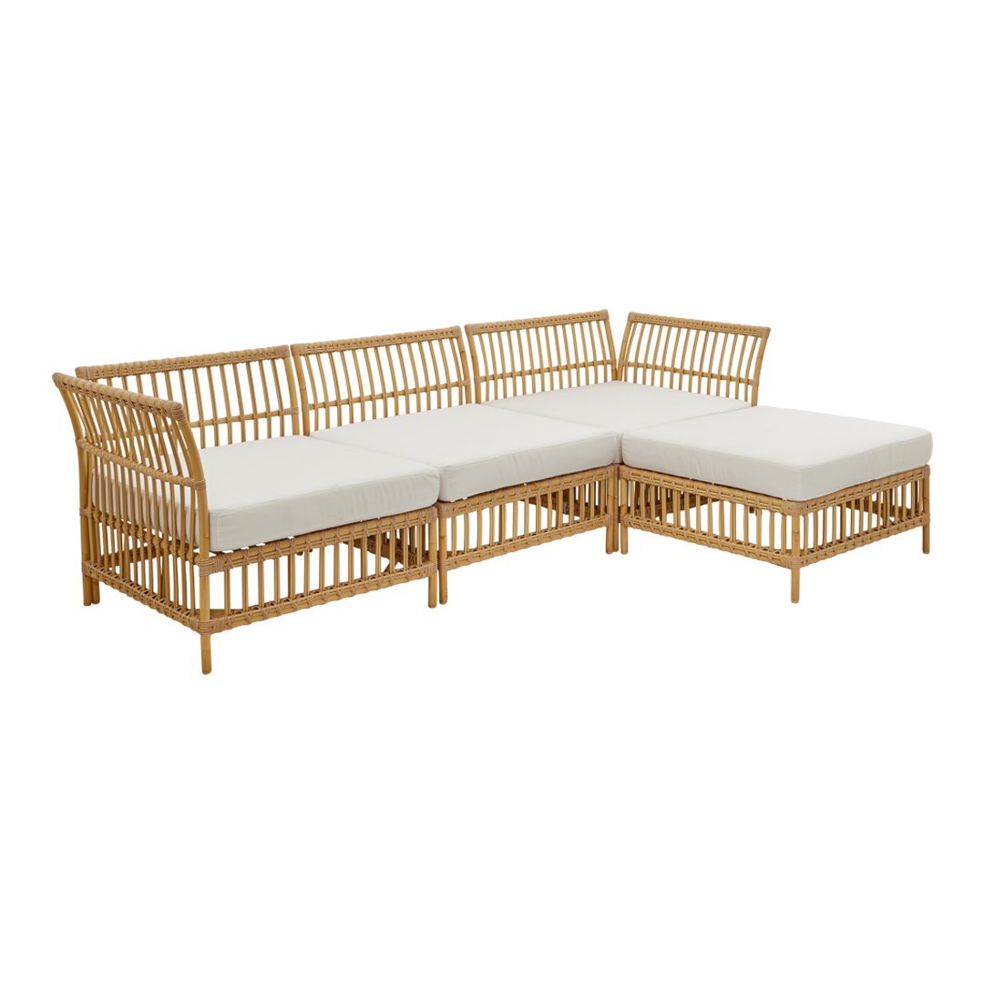 Light-colored fabric cushions with natural woven rattan frame in a minimalist design, perfect for outdoor spaces.