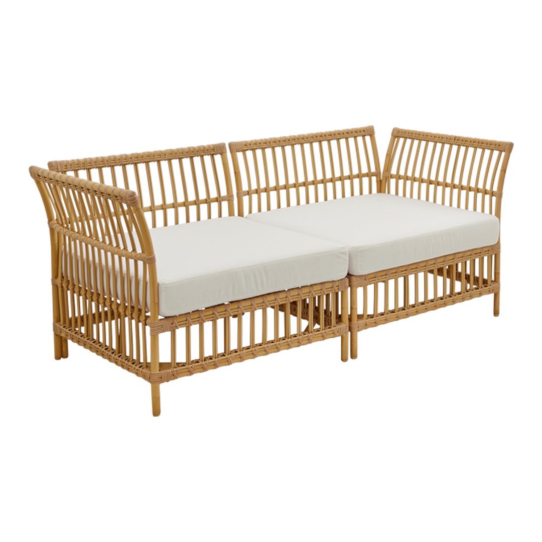Rattan sofa with natural bamboo finish and cream cushions, featuring a slatted design for a modern touch.