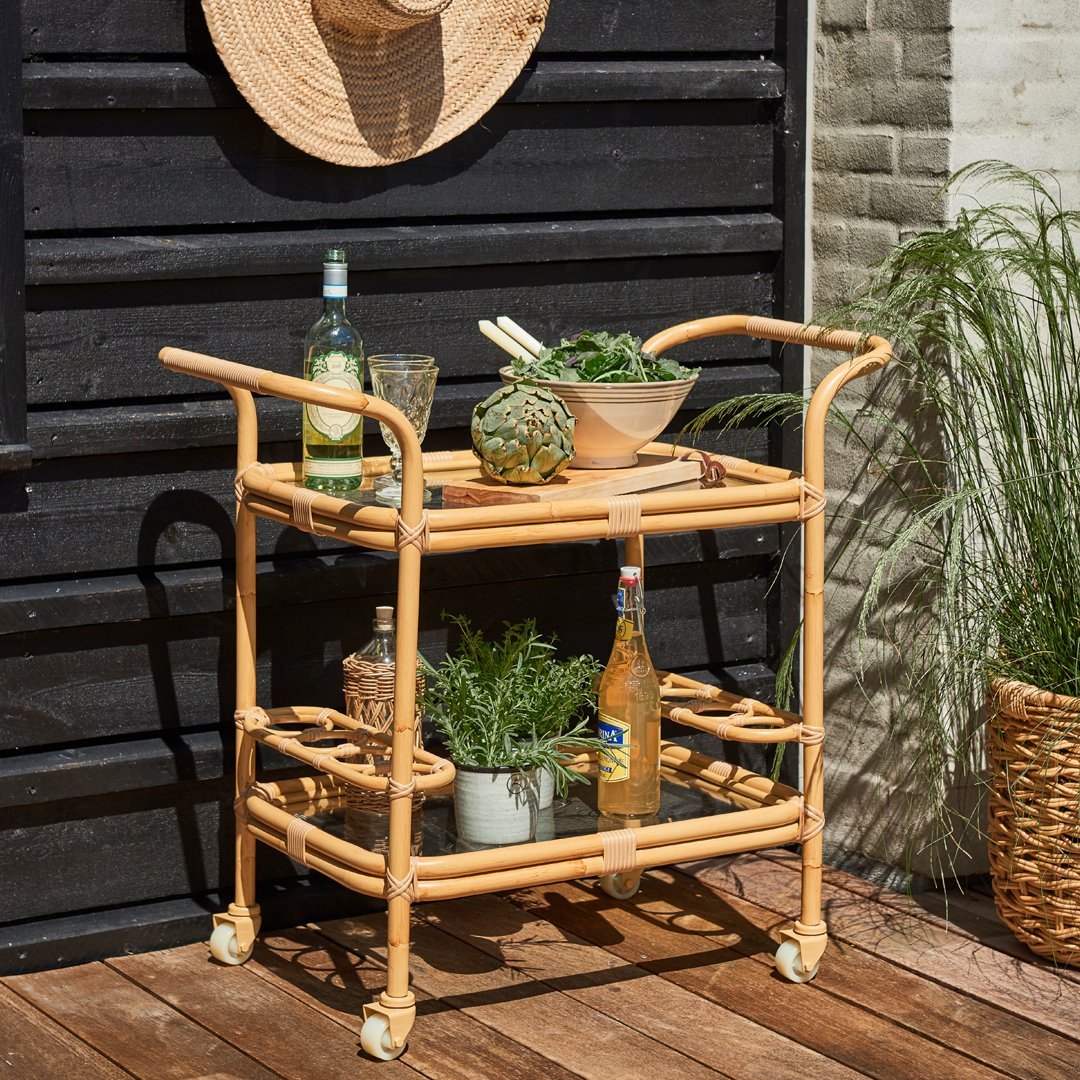 Natural rattan serving cart with a light brown finish, featuring open shelves and a simple, elegant design.