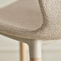 Beige textured upholstery with a subtle weave pattern, complemented by light wooden legs.