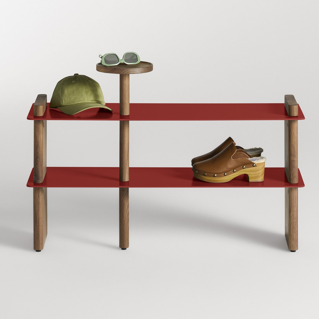 Red shelves with wooden accents display a green cap, sunglasses, and brown clogs, highlighting a modern aesthetic.