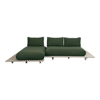 Stylish modern sofa in deep green fabric with sleek neutral base and clean lines for contemporary decor.