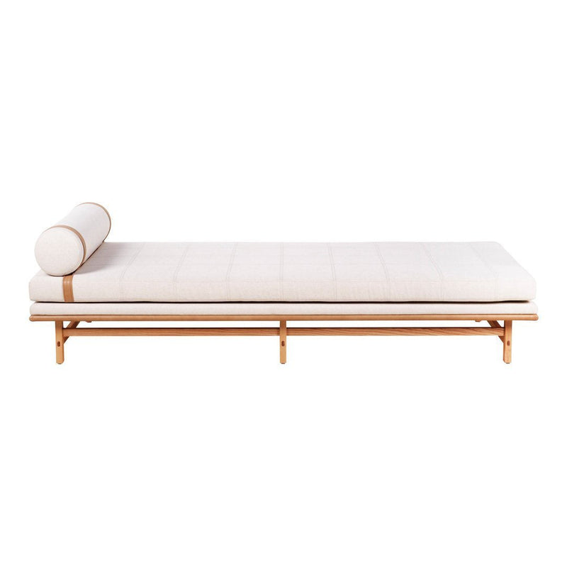 Light beige chaise lounge with a simple design, featuring a cylindrical pillow and natural wood frame.
