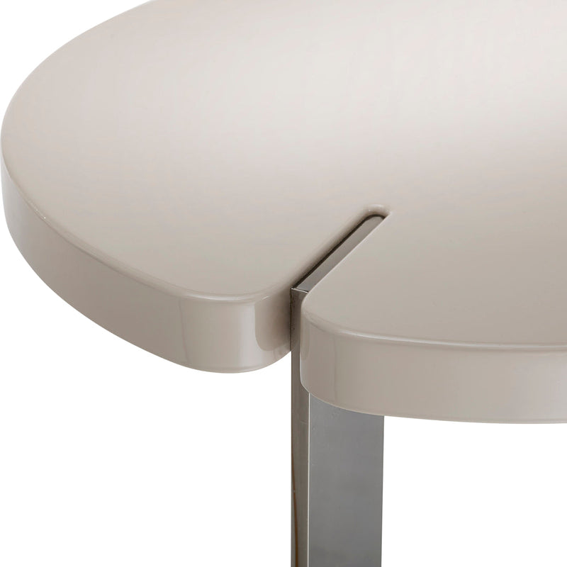 Beige round table edge with a smooth finish and subtle cutout detail, featuring a sleek silver leg.