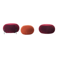 Colorful poufs featuring deep burgundy, vibrant orange, and soft red hues with smooth, round shapes.