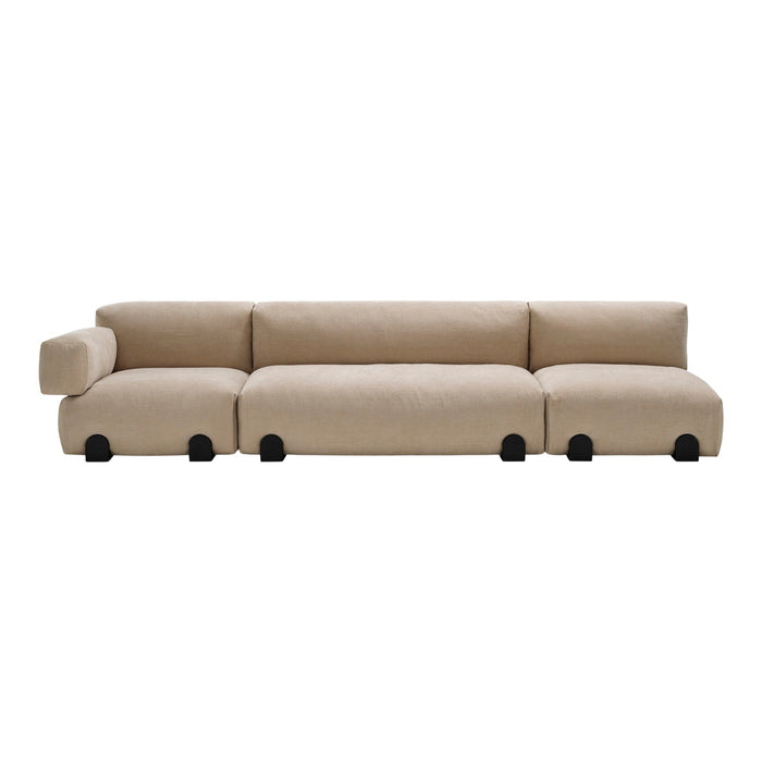Beige sectional sofa with smooth, minimalist design and black circular feet for a modern touch.