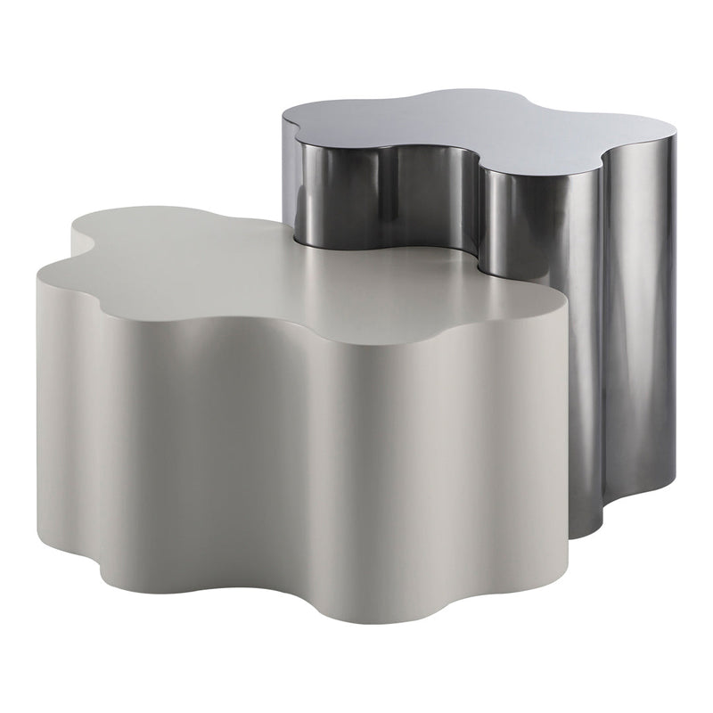 Two modern, sculptural tables in sleek silver and soft gray with a playful, organic silhouette.
