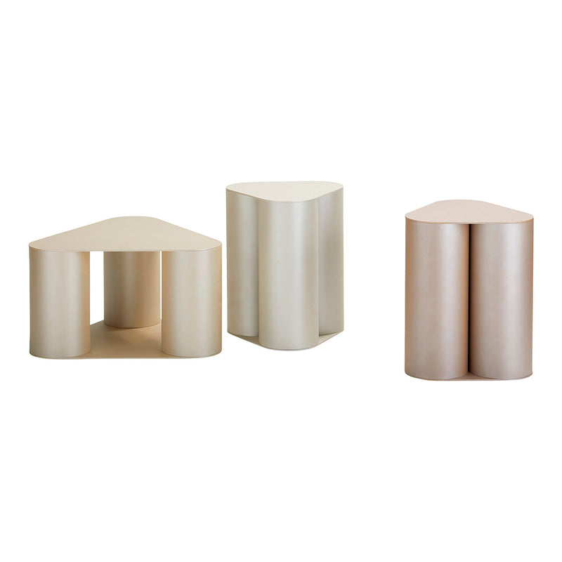 Set of three modern side tables in soft beige and light pink tones with smooth, minimalist shapes.
