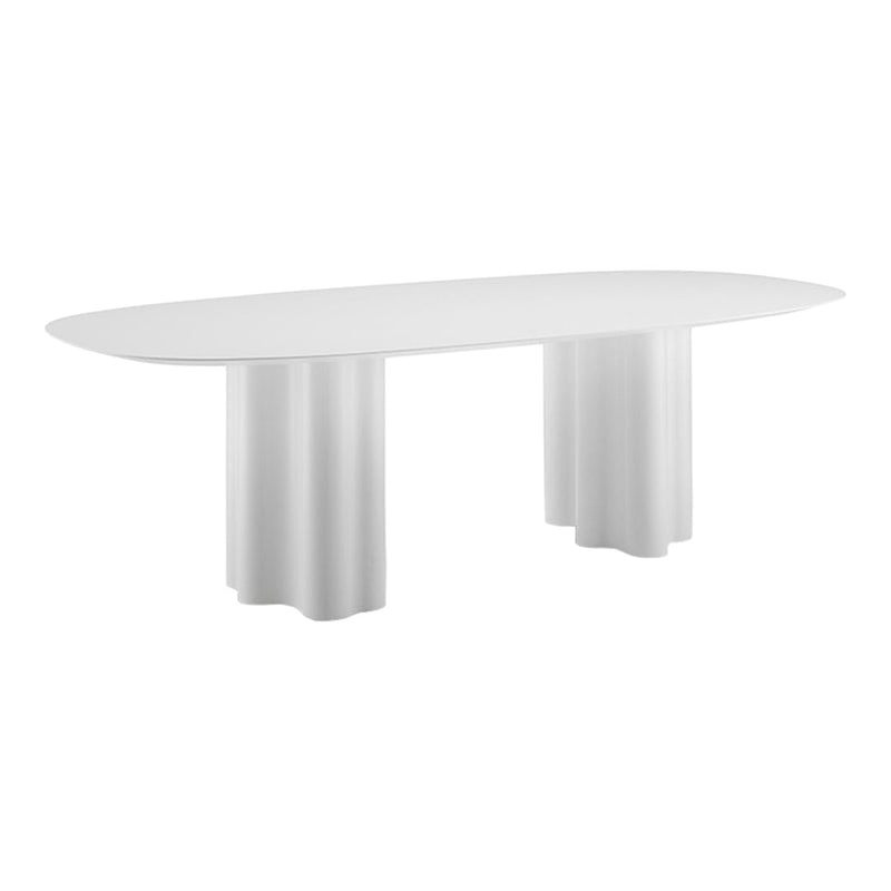 White oval dining table with a smooth surface and unique fluted cylindrical legs. Elegant modern design.